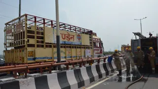 नोएडा के एलिवेटेड रोड पर सेक्टर-33 के पास खाली गैस सिलेंडर लदे ट्रक में लगी आग को बुझाने में जुटे अग्निशमन कर्मी। जागरण