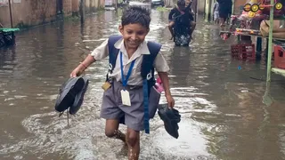 झरिया के बकरहट्टा मोड़-आमलापाड़ा मार्ग पर बारिश के पानी के बीच घर जाता स्कूली बच्चा। (फोटोः इजहार)