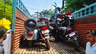 बागपत में तहसील के पास से जब्त किए गए स्कूटर व बाइकों को लेकर जाते विभाग के कर्मचारी। जागरण