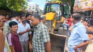 अतिक्रमण हटाने के दौरान बुलडोजर के सामने खड़े होकर विरोध करते सदर विधायक डॉ. मनोज प्रजापति