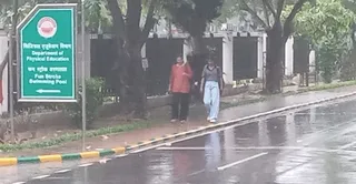 बारिश के दौरान छत्रपति शाहू जी महाराज विश्वविद्यालय में गुजरती छात्राएं। जागरण