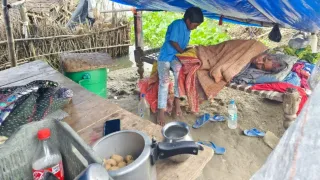 बाढ़ के पानी के बीच बीमार नानी की देखभाल करता नाती। जागरण
