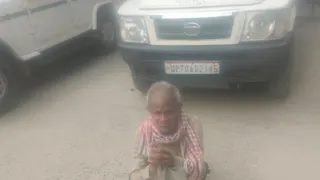 प्रयागराज के गंगापार स्थित सोरांव में तहसीलदार की गाड़ी के सामने बैठे पीड़ित ननकू। जागरण