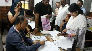 लक्ष्मी देवी स्कूल में लगे शिविर में एसआईआर के लिए नोटिस मिलने के बाद बीएलओ के पास दस्तावेज लेकर पहुंचे लोग। हरीश कुमार