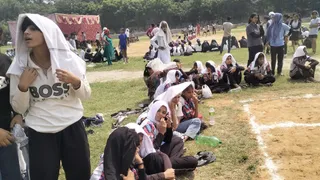 मैदान पर न छांव की व्यवस्था और न टेंट का सहारा। तपती धूप में सिर पर कपड़ा ढके मैच का इंतजार करतीं खिलाड़ी। अशोक कुमार यादव
