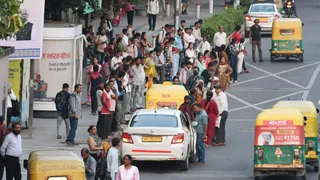 आईटीओ बस स्टॉप पर बस का इंतजार करते लोग।
