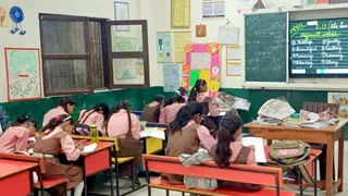 स्कूल में निगरानी के बीच पढ़ते बच्चे