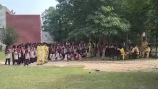 बम से उड़ाने की धमकी मिलने के बाद खुले में बैठे स्टूडेंट्स।