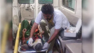 घायल महिला का इलाज करते एम्बुलेंस कर्मी।