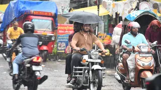 बारिश के बीच मुजफ्फरपुर के कल्याणी चौक से गुजरते लोग। फोटो: जागरण