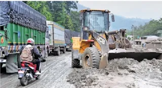 नेपाल के धादिंग के बैरेनी में सड़क पर जमा सिल्ट को हटाता बैकहोलोडर। -जागरण सूत्र