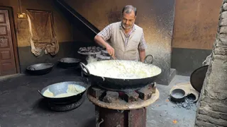 मथुरा के तरौली में लच्छेदार रबड़ी बनाते हरी सेठ।
