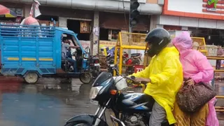बारिश के बीच से गुजरते बाइक सवार।