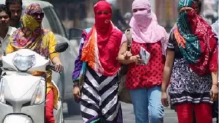 Mathura Weather Today: धूप से बचने के लिए चेहरे पर स्कार्फ पहनकर निकलतीं युवतियां।