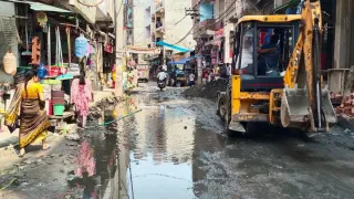 खोड़ा में सड़क पर जलभराव के बीच गुजरते लोग। जागरण आर्काइव