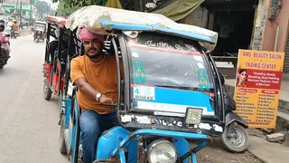 वाराणसी में सपा कार्यकर्ता ने टोटो चलाकर किया विरोध, उपमुख्यमंत्री को दी चुनौती।