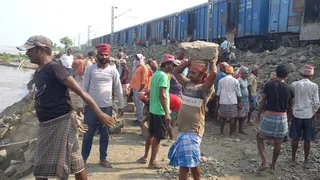 गंगा के कटाव से रेल पटरी को सुरक्षित बनाने के लिए काम करते मजदूर। (फोटो जागरण)