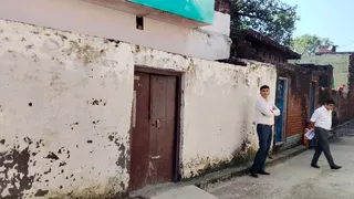 फेरीवाले के पोशाकी लाल के घर के बाहर खड़े ईडी के सदस्य