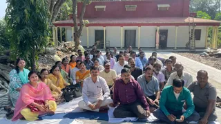 प्राचार्य कार्यालय के सामने धरना देते शिक्षक और कर्मचारी।