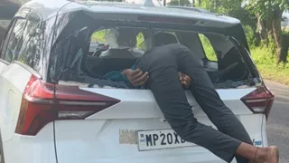 टकराने के बाद कार में जा घुसा युवक।