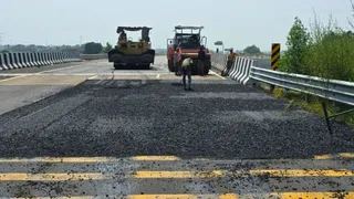 बड़ौत के पास दिल्ली-देहरादून इकोनॉमिक कॉरिडोर पर सड़क की मरम्मत करते कर्मचारी। जागरण