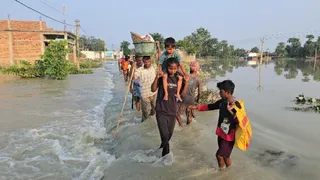 सारण में बाढ़ के बीच सुरक्षित स्थान की ओर जाते प्रभावित लोग। जागरण