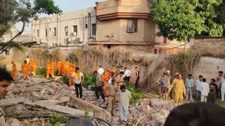 होटल में निर्माण कार्य के दौरान दीवार ढहने से मलबे में दबे श्रमिकों की तलाश करती टीम।