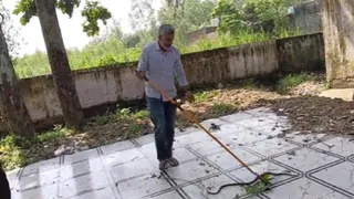 गांव योगेंद्र नगर स्थित कंपोजिट विद्यालय में सांप को पकड़ते शिक्षक राजीव सहरावत। सौ.स्कूल