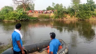 नकटिया नदी में युवक की तलाश करते गोताखोर