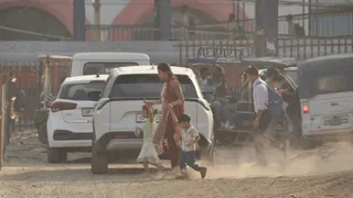 धूल के गुबार में सफर की मजबूरी...गाजियाबाद रेलवे स्टेशन परिसर में कच्ची और धूलभरी सड़क से वाहनों के गुजरने पर उड़ती धूल के बीच अपने बच्चों के साथ गुजरती महिला। अनिल बराल