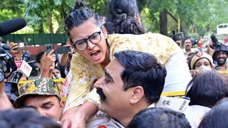 बैरिकेड पर चढकर प्रदर्शन करती प्रदर्शनकारी। चंद्र प्रकाश मिश्र