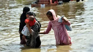 फैजुल्लागंज के मामा कॉलोनी में जलभराव के बीच जाते लोग। जागरण