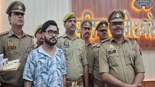 प्रयागराज के पुलिस लाइंस स्थित त्रिवेणी सभागार में आरोपित को मीडिया के सामने पेश करते पुलिस कर्मी। जागरण