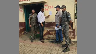 गिरिडीह के हथबोर गांव में सौरव पांडेय के घर पर इश्तेहार चिपकाती पुलिस और सीआइटी की टीम।