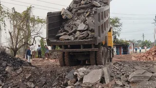धनबाद-बोकारो मुख्य मार्ग पर केंदुआडीह में बने गड्ढे की तेजी से हो रही भराई। (फोटो जागरण)
