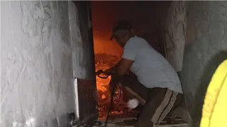 करहल में घर में लगी आग को बुझाने की कोशिश करते लोग।
