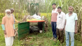 पिंजरे के पास खड़े ग्रामीण