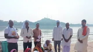 नदी के तट पर पिंडदान करते तर्पणार्थियों से बात करते शोधार्थी । सौ. स्वयं