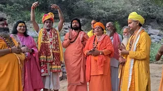 गिरिराज तलहटी में शिकांगो से आए प्रशांत त्यागी का पटका पहनाकर और साफा बांधकर स्वागत करते संत महात्मा। फोटो जागरण