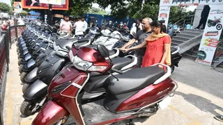 प्रयागराज के सिविल लाइंस में दोपहिया वाहन की खरीदारी करते लोग। जागरण