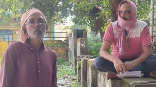 केंद्र में गमछा से चेहरा ढ़ककर बैठे जिला कृषि अधिकारी आरके वर्मा व पास में खड़ा किसान