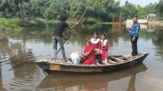 नाव से नदी पार करने को मजबूर ग्रामीण