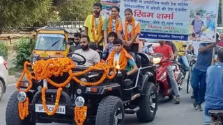 जुलूस के दौरान खुली जीप पर सवार रिदम शर्मा व कोच अजय कश्यप। सौ. आयोजक