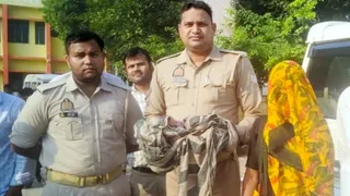 गुन्नौर सीएचसी में नवजात बच्चे को गोद में लिए खड़े पुलिस कर्मी। जागरण