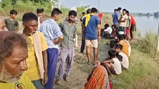 घटनास्थल के पास बैठे ग्रामीण।