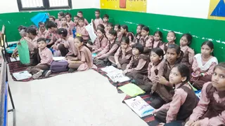 प्राथमिक विद्यालय रहमतनगर में पर्याप्त बेंच न होने के कारण जमीन पर बैठकर पढ़ते बच्चे।जागरण
