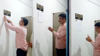 नेमप्लेट के नीचे ज्ञापन चिपकाते छात्र