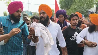 फरीदकोट में संदिग्ध गोलियों के साथ काबू युवक को पुलिस के हवाले करने के लिए जाते हुए हुए प्रदर्शनकारी।