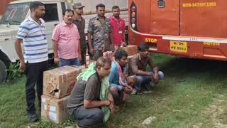 गिरफ्तार शराब धंधेबाज और जब्त बस के साथ उत्पाद विभाग की टीम। फोटो: उत्पाद