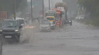 बागपत में दिल्ली-सहारनपुर हाईवे पर बरसात के दौरान गुजरते वाहन।